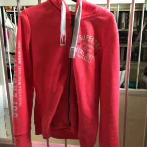 Neon rosa zip-Hoddie i bra skick från Superdry.  Storlek XL, känns mer som en L.  Ändvänd ett fåtal gånger. Jag säljer den för 280 kr, original pris 600 kr.