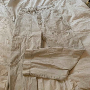  - Ett par svinsnygga lite ”cargo” liknande byxor från Weekday, raka i modellen och går ner till anklarna på mig (är 170 cm) Ljusbeiga med jättemånga snygga detaljer och bruna sömmar! Använda ett få tal gånger och köpa för 500 kronor 🤗