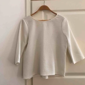  - Vit blus i krispigt material. Kommer ej till användning längre. Bra skick!