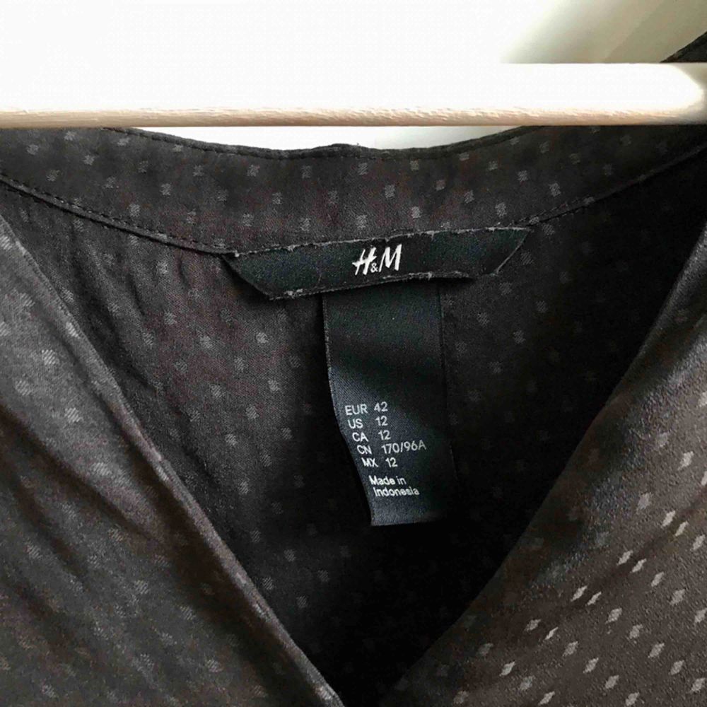 Mörkgrå blus från H&M. Små diskreta prickar i tygmönstret.    Köparen står för eventuell portokostnad. . Blusar.
