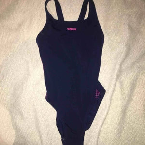 - Mörkblå baddräkt från arena med rosa mönster vid sidorna och ett hål på ryggen. 