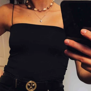  - Snyggt svart ”tub”-linne som aldrig är använt. Helt nytt.Tunna spagettistraps och rak skärning. Fler bilder kan skickas, frakt ingår ej.