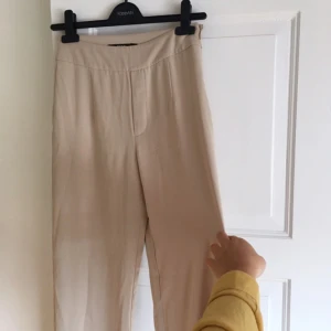  - De beiga slutsålda Adriana-byxorna från Bik Bok. Vida i benen och höga i midjan. Oanvända p.g.a. har ett par liknande, nypris 299kr.