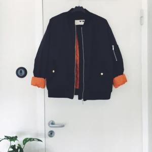  - Svart bomberjacka med orange innerfoder. Köparen betalar frakten. Kan även mötas upp i Göteborg! 