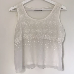  - Linné, blus med paljetter och genomskinligt tyg längst ner. 