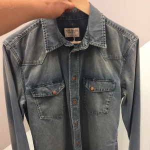  - Oanvänd skjorta från Nudie. Liten i storleken så passar både S-M