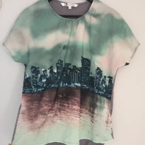  - Tröja med statsmotiv på framsidan och grå baksida, i storlek S.