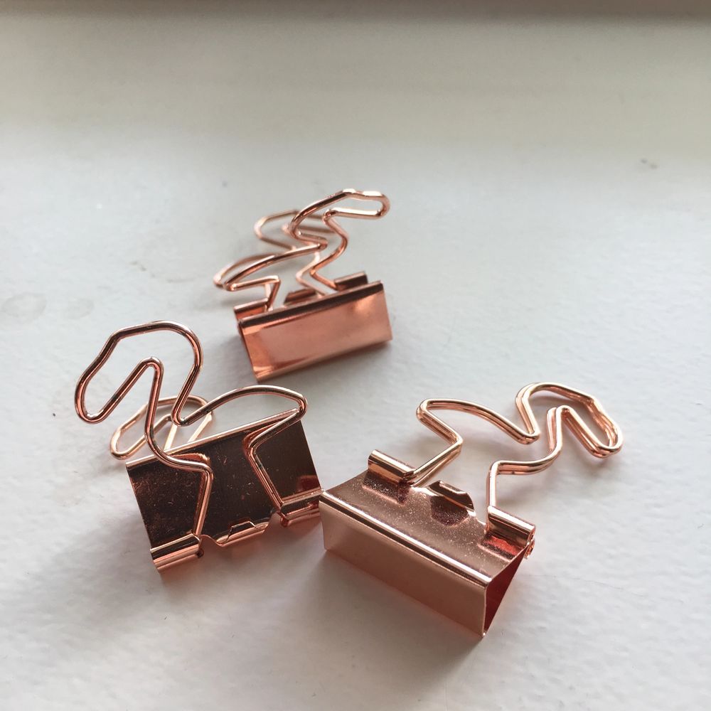 Klämmor i roséguld som ser ut som flamingos. Väldigt praktiska eftersom att de kan användas till allt. Samla ihop dina kvitton eller organisera viktiga papper eller häng upp en tavla med hjälp av dem. Jag använder inte just dessa. Därför säljer jag dem. . Accessoarer.