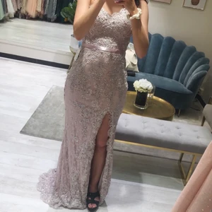 Mauve festklänning  - Nyköpt. Använd 1 kväll.  Mauve. Den är 34 men passar en 36. Vackra detaljer med en slit på sidan.