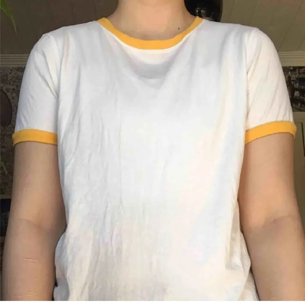 En unik thirt med gul/orangea detaljer runt huvud-hålet och ärmarna. Den är köpt för 300kr och använd endast ett fåtal gånger, så i nyskick.. Skjortor.