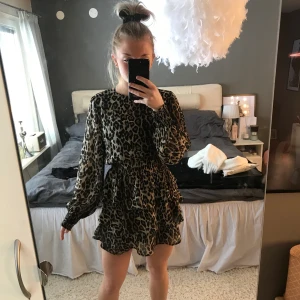 leopardklänning med volang - köpe denna på gina tricot för ett tag sen. använd max 5 gånger. Super fin att ha som den är eller med en stickad tröja över så det blir som en tröja och en kjol. Frakt tillkommer