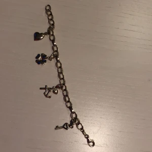 Silverarmband med 4 berlocker  - Armbandet är 17 cm lång i silver. De fyra berlockerna är hjärta, fyrklöver, tro hopp och kärlek, samt en nyckel med hjärta och diamanter. Varje berlock kostade 100-200 kr nypris och armbandet nånting sånt med