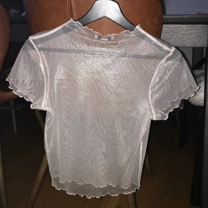 Ljusrosa mesh t-shirt från Topshop - Ljusrosa glittrig/skimrig mesh t-shirt med volangkanter från Topshop i storlek XS/S, jätte bra skick💗köpte den på Topshop butiken i Berlin.