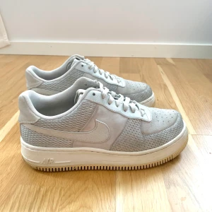 Nike Air Force 1/ blågrå/ storlek 40,5 - Nike Air Force 1 säljes i fint begagnat skick. Färgen är ljusblå/grå och skorna är i storleken 40,5. Material i äkta skinn och mocka samt tyg som andas bra. Mycket bekväma skor. Nypris 1 300 kronor. Kan postas! 
