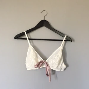  - Cremevit bygellös spetsbh från kollektionen KappAhl by Miss Vanity. Rosetten på bh-n är avtagbar och bh-n är i nyskick. Först till kvarn!