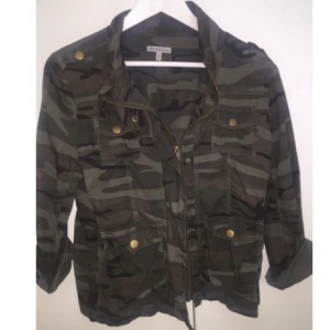  - Tunn kamouflagefärgade jacka med trekvarts-ärmar. Köpt i USA för ett år sen,
Mycket bra kvalité! 
Liten i storleken, enligt mig så skulle den även kunna vara en S