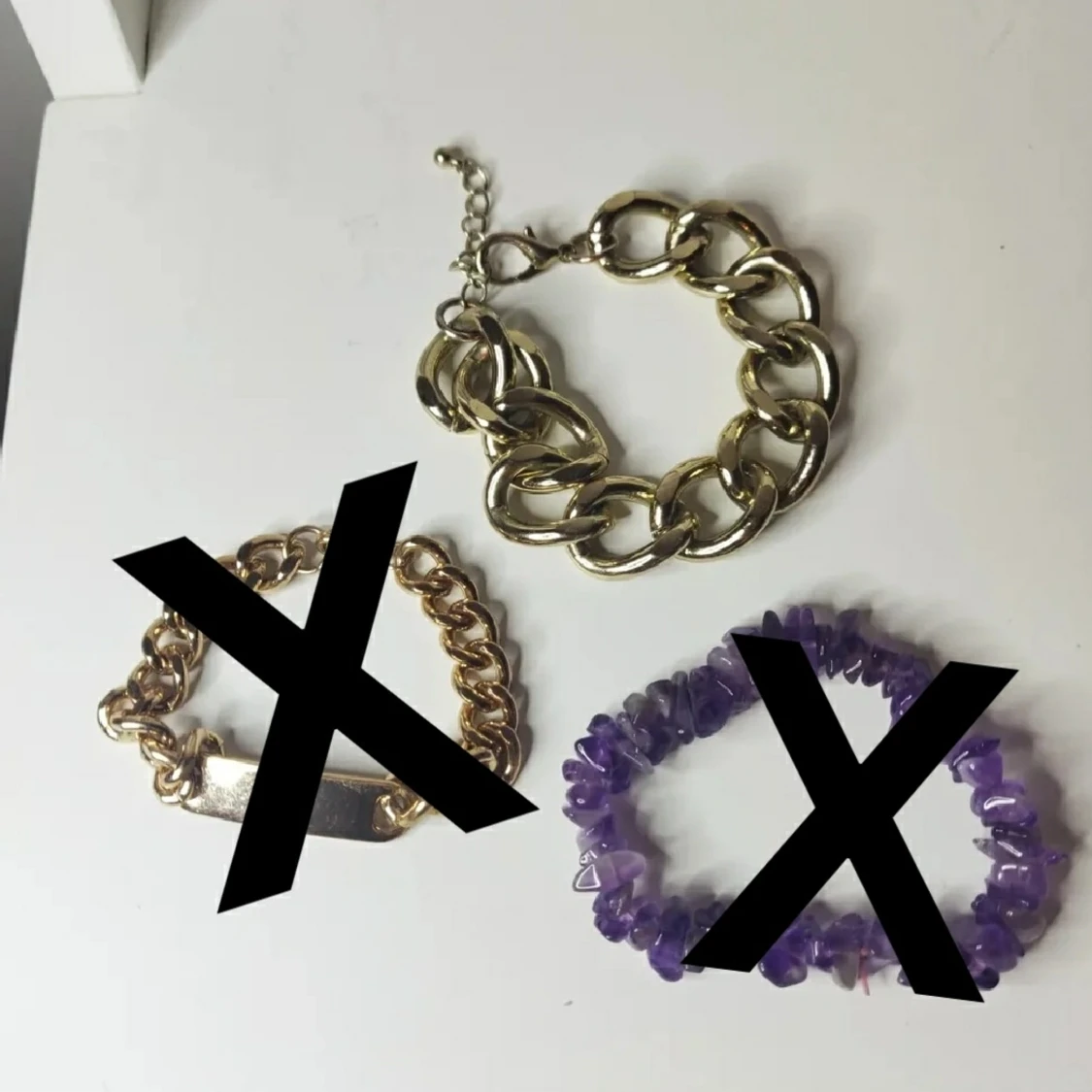 olika armband i guldfärg samt lila