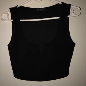 Svart topp från Nelly - Topp från Nelly som aldrig har använts pga dubbletter!! Den har en unik urringning och passar perfekt till fester eller liknande. Frakt ingår i priset.