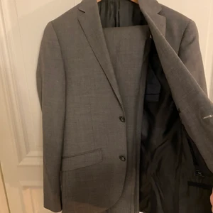 Grå Kostym - Snygg grå kostym från Riley, använd vid ett tillfälle och är i jätte bra skick. Storlek 46 som motsvarar S på ett ungefär. Perfekt till tillfällen du behöver klä upp dig till. Nypris 3000kr. 
