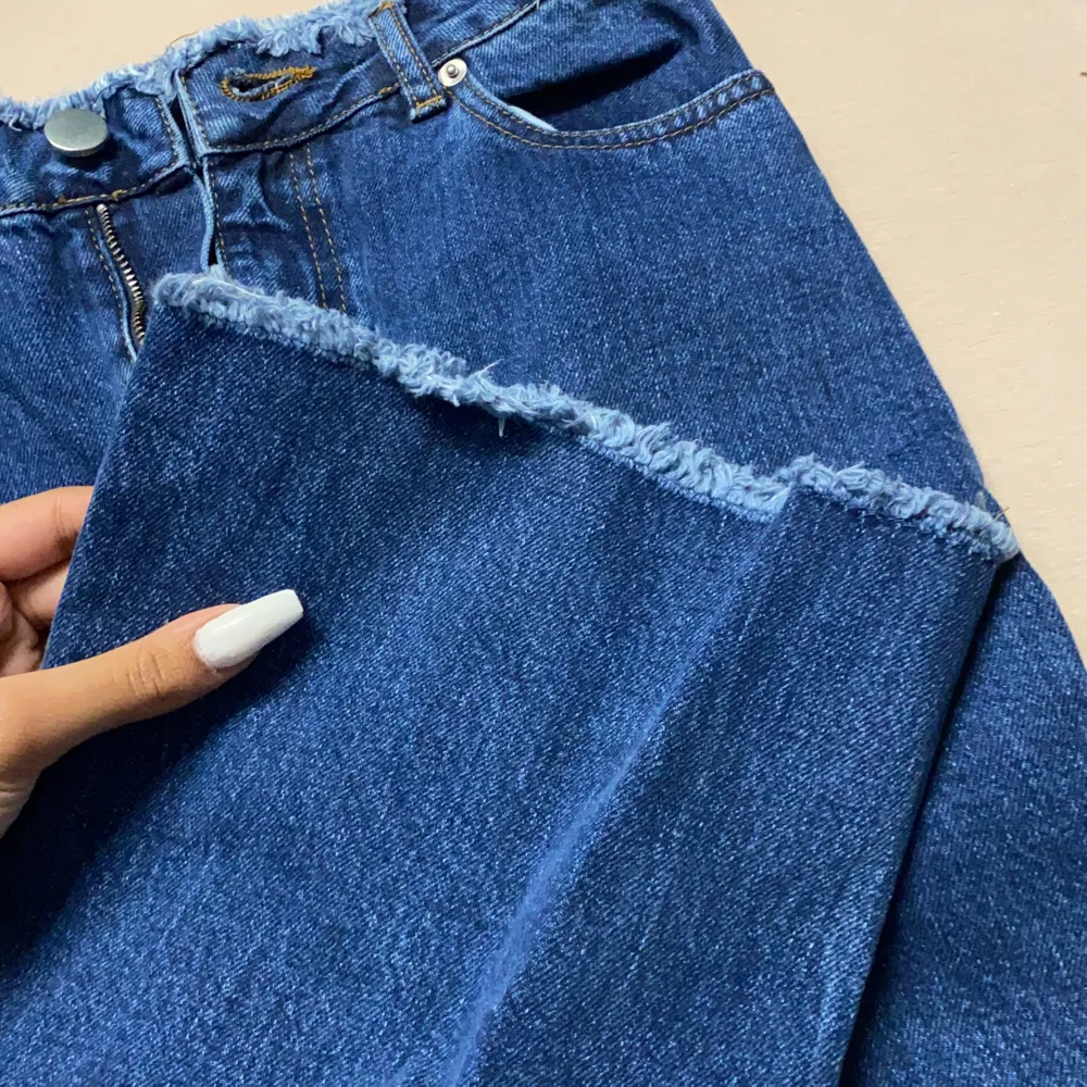 Ett par möekblåa denim jeans som e tajt uppe och lös där nere, lite som momjeans, får en fin form och sitter som ett smäck! Har fina detaljer både vid midjan och vid fötterna . Jeans & Byxor.