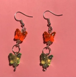 Fjärils örhängen :) - Egen gjorda örhängen med gröna och oranga fjärilar och små gröna pärlor.