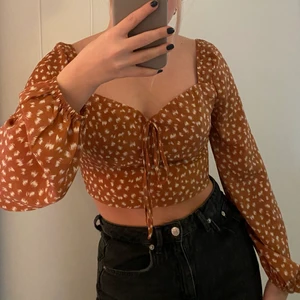 Brun topp - En brun croppad topp med balongärmar i strl S🤎 ser mer orange ut på bilden än vad den är i verkligheten. Stretchtyg på baksidan så den sitter inte hårt mot kroppen. Köparen står för frakt 