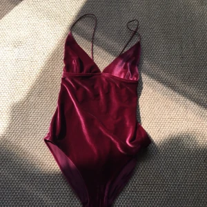  - Burgundy-röd sammets swimsuit/ body från Weekday. Snörning i ryggen, justerbara axelband. Låg skurning fram och bak, suupersnygg till fester och till lite extra vardagar!
