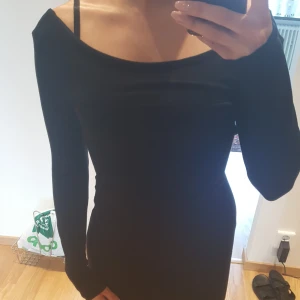  - Svart klänning med öppen rygg. Kortare framtill och längre bak.  Använd 1 tillfälle. Storlek s   Finns i Helsingborg men kan skickas mot fraktkostnad