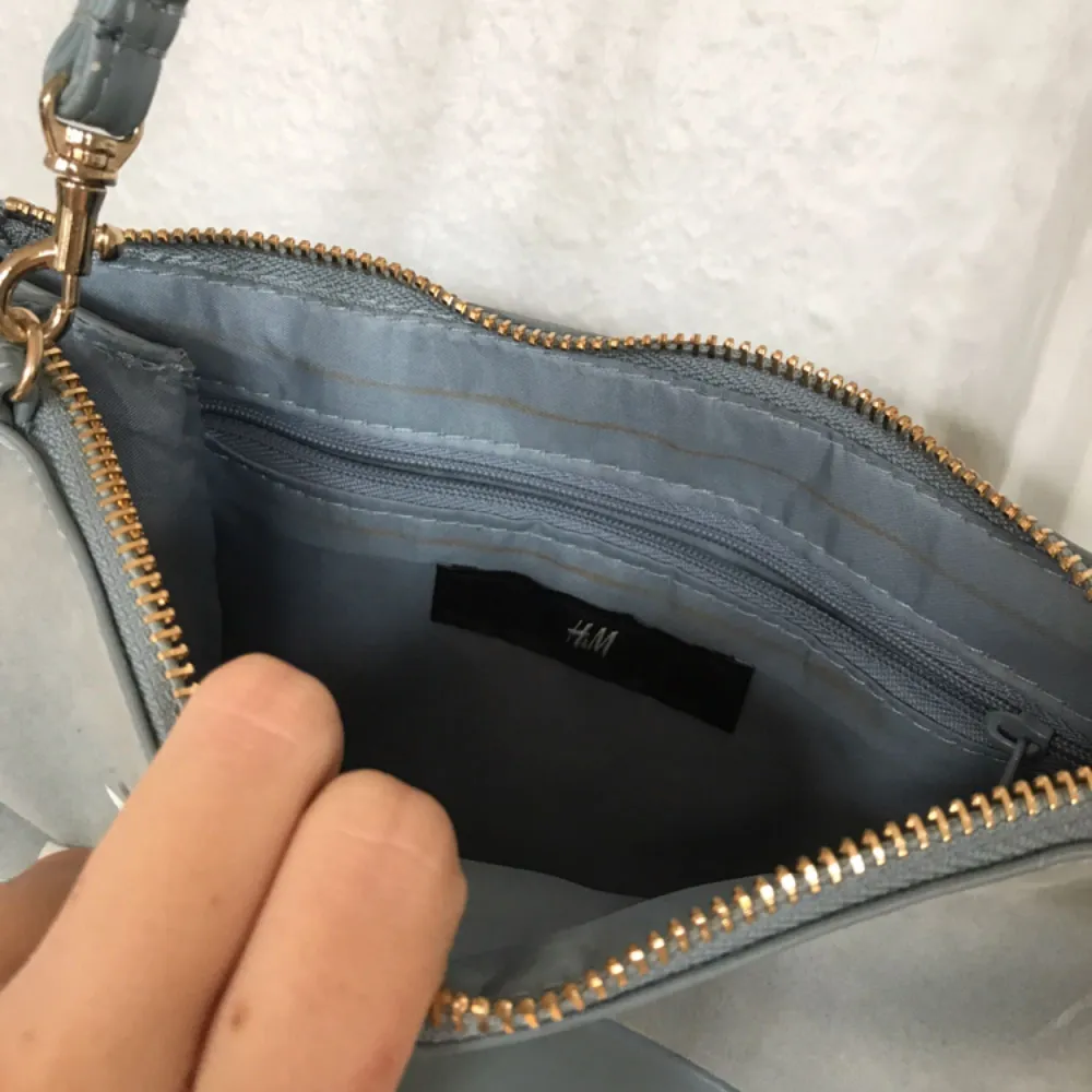Gulli liten ljusblå väska från H&M. Använd 2/3 gånger. Fått några konstiga bruna streck på insidan men jag har absolut inte spillt något alls i den då jag typ bara haft min plånbok och mobil i den, så det är nog inget! Frakt: 55kr🎈💌. Väskor.