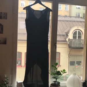  - Ursnygg figursydd svart klänning. Långt fall bak och kortare framtill. V-ringning i rygg och rundad hög ringning framtill. Väldigt fin passform i midjan 👌🏼