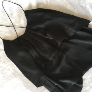  - Fin topp med korsade band i ryggen.