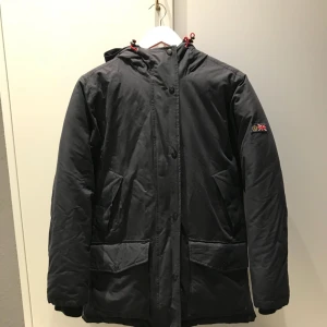  - Dags att säga hej då till min marinblåa dunjacka som jag köpte för två säsonger sedan på NK sport och fritid.  Den är i extremt bra skick då den använts vad jag skulle kalla för minimalt. Det är storlek 2 på jackan och jag skulle säga att den är som en SMALL i storleken. Den är lite tightare och formar sig fint på kroppen.   Den håller värmen ofattbart bra och det är en skön längd som även täcker rumpan. Ett bra kap helt enkelt som är värd den allra bästa.   Nyspris: 4500 kr, idag säljer jag den för 1700. 