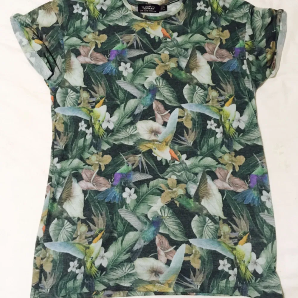 Mjuk go t-shirt med fåglar och blommor i tyget. . T-shirts.