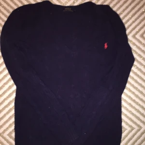  - Aldrig använd Marinblå polo Ralph Lauren kabelstickad dam tröja. Strl xs passar bra på en S. Äkta köpt på nk i Stockholm. Original pris: 600kr Mitt pris:449kr (pris kan diskuteras vid snabbt köp) (använder swish)