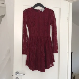  - Nelly trend klänning, långärmad fodrad kropp och spetsärmar Tight upptill och klockad kjol  Vinröd spets Nypris 500:-  Dragkedja i ryggen (dold) Använd EN gång, mycket fint skick! 