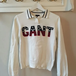  - Vit tröja med GANT skrivet fram. Snygg krage med mörkblå rand. Knappar i halsen. 100% bomull. Mindre än en M, mer en S. 