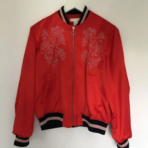  - Röd bomberjacka i sidenmaterial. Använd fåtal gånger. 