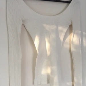 Vit topp - En vit tight topp från H&M med djup rygg. Använd en gång, så den är i nyskick. Storlek XS 