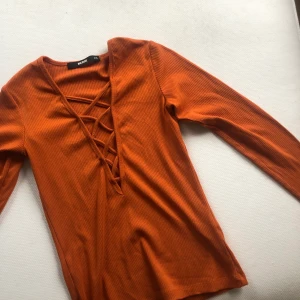 Tajt tröja med urringning!  - En bronsfärgad tajt tröja från Bikbok! Väldigt fint skick! Frakt tillkommer 30 kr!