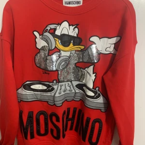 H&MOSCHINO sorlek M  - Tröjan är använd men är i gott skick. Tröjan är från HMs kollektion med Moschino, den är i storlek M.