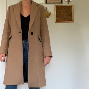 Kappa från Zara - Beige, lång kappa från Zara. Lite nopprig men annars i fint skick. I storlek XS men passar mig som är S. Perfekt till hösten! 