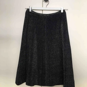  - Vintagekjol i fint skick! Marinblå med metallic/silver glittrig, stickad med fint fall och mycket stretch! 75% bomull, 25% metallic fibers.