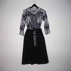 Underbar djurisk klänning från 60/70-talet i polyester från mormors garderob. Dragkedja i sidan, knälång med ett avtagbart band i midjan