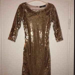  - Klänning med Guldiga paljetter både fram och bak, ryggen har en öppning som på bilden, andvänd 1 gång 