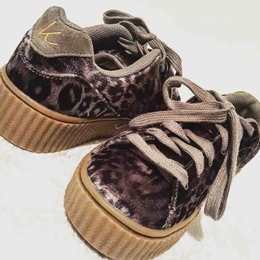 Sneakers från K. Cobler med grov mörk gul/brun sula. Skorna är i grått leopardmönstrat sammetstyg. Endast använda två gånger då jag snabbt upptäckte att de är för små för mej (har storlek 36,5). Nypris 699kr. Köparen står för frakten. . Skor.
