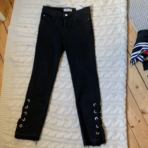 Jeans från Mango - Jättefina jeans från Mango med snörad slits längst ner på benen. Knappt använda. (FRAKT TILLKOMMER)