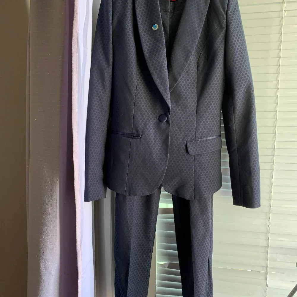 En mörkblå stilren kostym från LA City i str. 34. Kavaj med byxor. Köpt i Frankrike 1år sen för 200 € använd ett par gånger. Säljes för att nu den är lite för små för mig. Den är i nyskick inga defekter. Jättefin kvalite. Kan köras till Sthlm för avhämtning om önskas.. Kostymer.