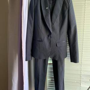 En mörkblå stilren kostym från LA City i str. 34. Kavaj med byxor. Köpt i Frankrike 1år sen för 200 € använd ett par gånger. Säljes för att nu den är lite för små för mig. Den är i nyskick inga defekter. Jättefin kvalite. Kan köras till Sthlm för avhämtning om önskas.