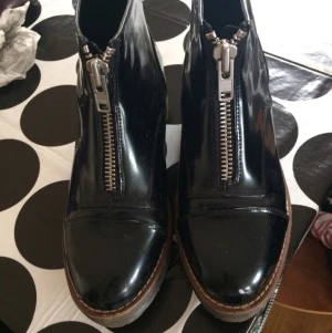  - Snygga boots med dragkedja i svart lack och grov sula. Märket River Island.
Väldigt bekväma. 
Frakt tillkommer.
