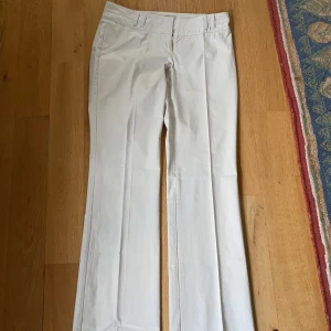 Byxor kostymbyxor 38 - Underbara byxor i din kostym modell med pressveck o vida härliga ben. Lite glansiga i materialet 94%bomull o 6%elastan. Ljus beige i färgen. Frakt tillkommer 70kr 